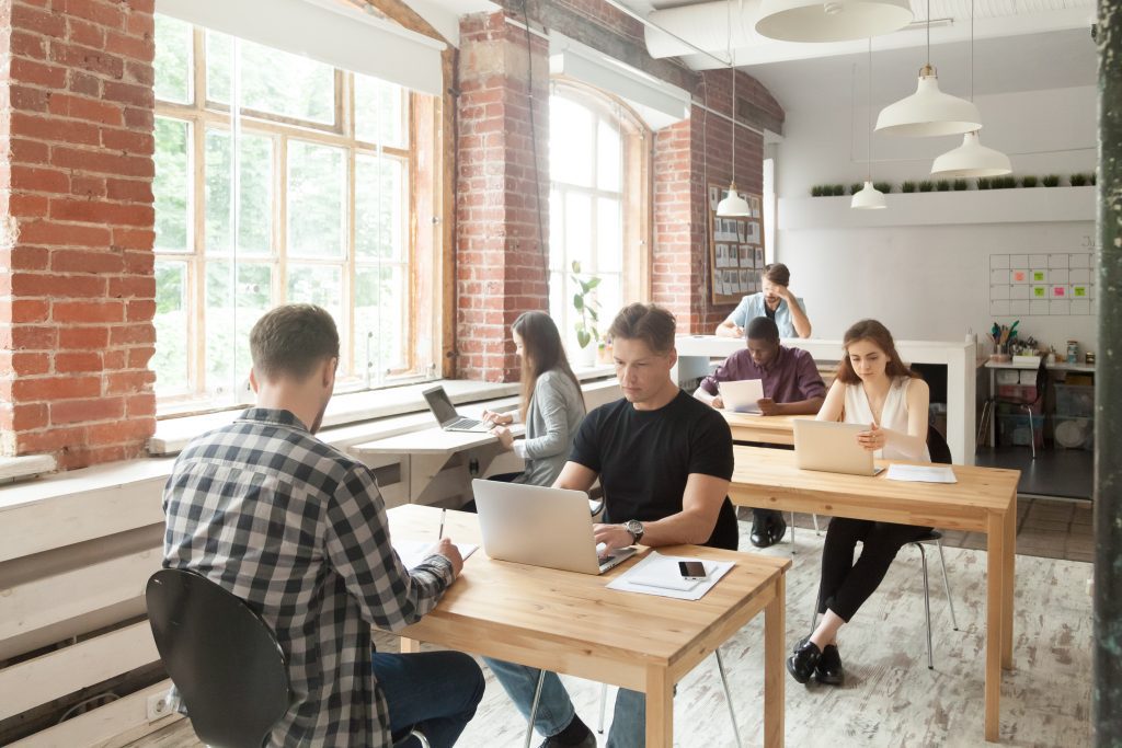 Young casually dressed employees at work in shared coworking off