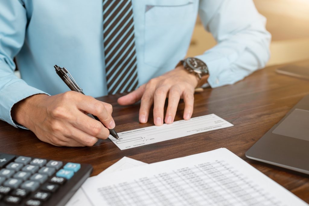 Businessman hands writing and signing check. business, finances