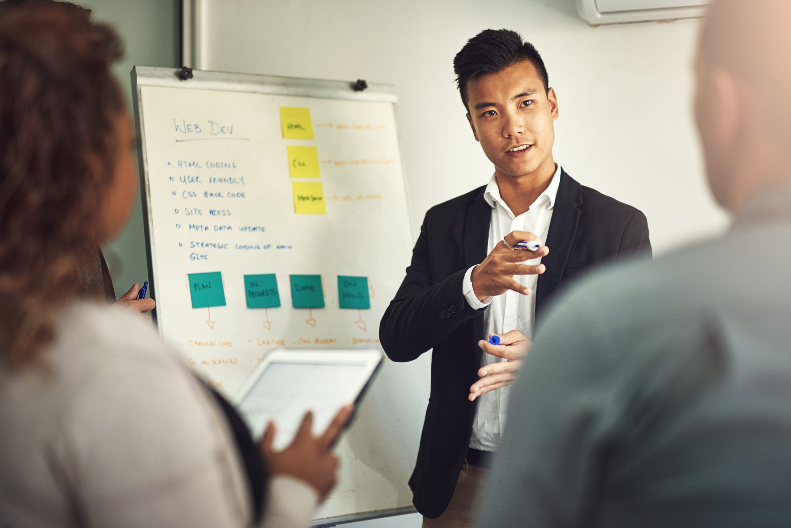 Fielding questions from his team. Shot of a young man giving a presentation to colleagues in an office. Shot of a young man giving a presentation to colleagues in an office.